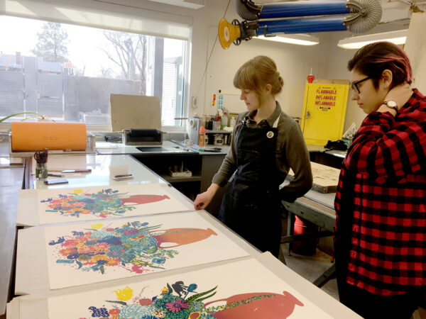 Printers looking at proofs of lithographs in printmaking studio